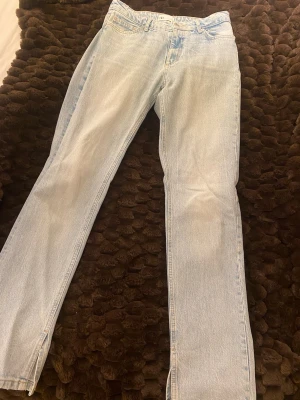 Ljusblå raka jeans från Zara - Säljer ett par ljusblå jeans från Zara med raka ben och hög midja. Jeansen har klassisk femficksdesign, dragkedjegylf och en liten slits längst ner på benen. Materialet är mjukt denim i bomull och passformen är normal. Perfekta till sneakers eller boots.