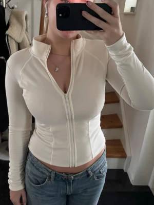 Vit ziptröja - Säljer en vit tröja med dragkedja. Tröjan har lång ärm och figurnära passform, perfekt till jeans eller kjol. Materialet känns mjukt, vilket gör den riktigt bekväm och snygg. Aldrig använd och ifrån Shein