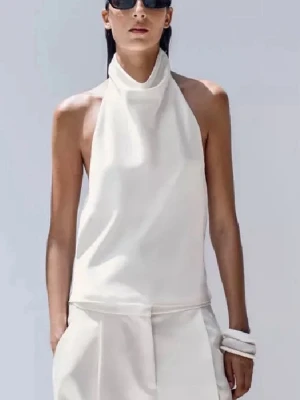 Vit halterneck topp i satin från Zara - Supersnygg vit halterneck topp från Zara i glansigt satinmaterial. Säljar den då för att jag är lite för stor för mig och jag vill ha en ny storlek xs 🫰🏻🩶 helt öppen rygg ☝🏼