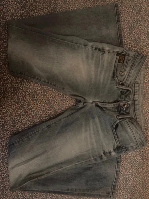 G-Star grå jeans med broderad ficka - Säljer ett par skitsnygga blå lågmidjade utsvängda jeans från G-star .Perfekta till sneakers eller boots.