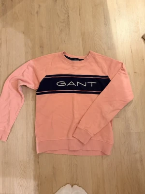 Gant tjocktröja  - Super fin GANT tjocktröja i en gammelrosa färg, med ett marinblått tryck. Mycket bra skick, sällan använd. 