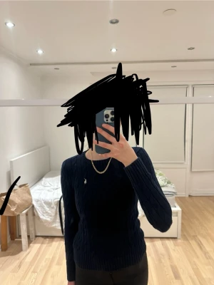 Marinblå kabelstickad tröja Polo Ralph Lauren - Säljer en marinblå kabelstickad tröja från Polo Ralph Lauren i storlek XXS. Tröjan har rund halsringning, lång ärm och den klassiska broderade loggan på bröstet. Perfekt till höst och vinter för en clean och tidlös look.