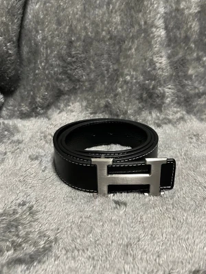 Snyggt svart läderbälte - Snyggt svart läderbäte med H spänne, aldrig använt, skriv vid frågor!