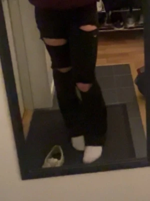 Svarta bootcut jeans med håll - Säljer ett par svarta bootcut jeans med  hål. Jeansen har hög midja men jag själv brukar vika ner dom så dom blir lågmidjade. I storlek xs
