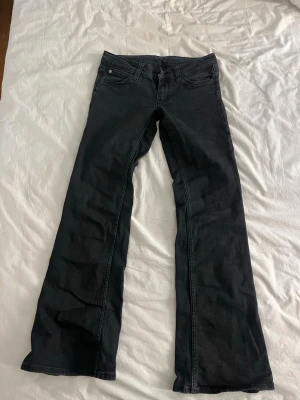 Svarta bootcut jeans Cheap Monday - Säljer ett par svarta bootcut jeans från weekday i modellen Cheap Monday i storlek 31/32. Jeansen har klassisk femficksmodell, låg midja och är tillverkade i ett mjukt bomullsmaterial med lite stretch. Snyggt svarta med diskret Cheap Monday-logga bak.