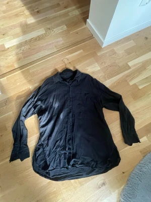Svart linneskjorta - En svart linneskjorta med klassisk krage och knäppning framtill från BikBok storlek L. Den har en liten missfärgning på ena armen (se sista bilden) därav priset 