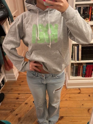 Grå hoodie med grönt tryck - Mysig hoodie!