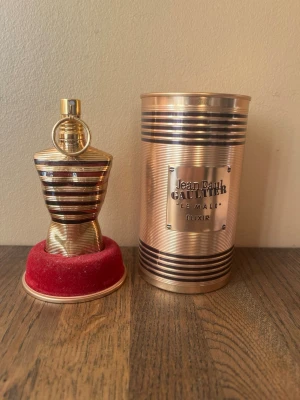 Le Male Elixir Limited Edition - Upptäck Jean Paul Gaultier Le Male Elixir – en ikonisk parfym i en unik, guldskimrande flaska. Perfekt för dig som vill sticka ut och addera en lyxig touch till din stil. Snygg förpackning som drar blickarna till sig. Parfymen är så gott som full.