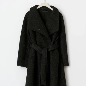 Lång teddy jacka svart gina tricot - Säljer en svart lång boucle kappa från Gina Tricot med bred krage och bälte i midjan. Jackan har en oversized passform och är tillverkad i mjukt syntetmaterial. Perfekt för dig som gillar en chill och trendig look under höst och vinter.