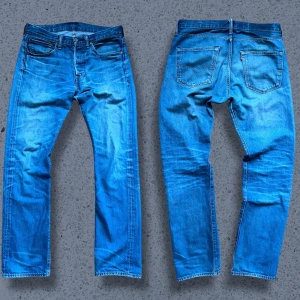 Levis 501 - W31 L32, se beskrivningen för fler mått. Ett par riktigt fina Levis jeans med snygga fades och honeycombs! Märket på baksidan har lossnat. Priset är inte hugget i sten, hör av dig vid minsta fundering! Mått (+-1): Längd 103cm IB längd 75cm Benöppning 18cm Midja 41cm Lår 25cm