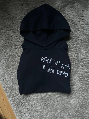 Mörkblå hoodie Zadig & Voltaire - Mörkblå hoodie från Zadig & Voltaire med vitt tryck ”rock ’n’ roll is not dead” på bröstet. Klassisk känguru ficka framtill, huva och långa ärmar. Mjuk bomullskvalitet med relaxed passform. Storlek S men passar M. Nypris ligger på 2450kr