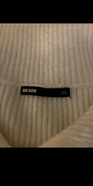 Vit ribbad tröja - Säljer en vit ribbad kofta från Bik Bok i storlek XS.            Lite nopprig!
