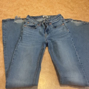 Low waist bootcut jeans med slitna lite där nere - Säljer ett par blå bootcut jeans med slitna där nere. Jeans är från lager 157 (low waist bootcut) jag säljer då den inte passar längre
