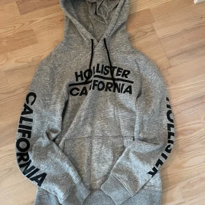 Hollister hoodie med tryck - Säljer denna snygga hollister hoodie. Snygga tryck på både bröstet och armarna. Perfekt nu till vintern. Om ni har någon fundering är det bara att höra av sig.