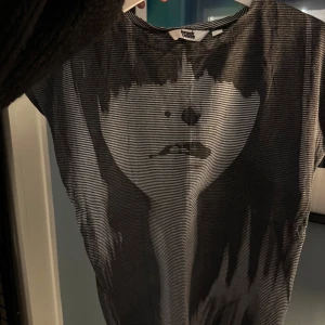 Cool t-shirt - Cool svartvit t-shirt från Invisible Castle med  ett stort grafiskt ansiktsmotiv på framsidan.