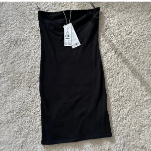 Svart off shoulder klänning från Gina Tricot - Helt ny oanvänd klänning med prislappen på. Klänningen är en tight off shoulder klänning i superstretchigt material. Nypris 299kr. Klänningen är kort och axelbandslös, med en minimalistisk och stilren look. Perfekt för dig som gillar en enkel men snygg outfit. Säljes i storlek S.