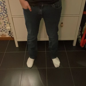 Blå jeans från Jack & Jones - Säljer ett par klassiska blå jeans från Jack & Jones i storlek 31/32. Jeansen har en rak passform med snygga kontrastsömmar och femficksdesign. Tillverkade i mjukt denimtyg som sitter skönt hela dagen.