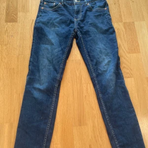 Levi's 512 Slim Taper jeans blå - Snygga Levi's 512 Slim Taper jeans i klassisk mörkblå tvätt. Modellen har smal passform med avsmalnande ben, fem fickor och detaljerade sömmar. Perfekt för dig som gillar en modern och stilren look. Ikonisk Levi's patch baktill.