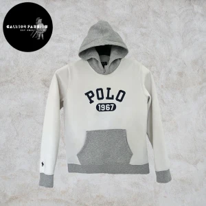 Polo Ralph Lauren hoodie - Polo Ralph Lauren hoodie i storlek 14‑16 (motsvarar XS‑S) med grå huva, grå muddar och grå känguruficka. Texten “POLO 1967” är tryckt på bröstet och den ikoniska Polo‑logotypen är broderad på vänster ärmslut. Finns inte längre att köpa ny och är svår att hitta på andrahandsmarknaden, ett riktigt unikt fynd! Skicket är toppen nästintill nyskick. ~ Nypris cirka 1 900‑2 500 kr | Vårt pris 895 kr. Alla följare får rabatt – följ!