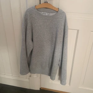 Grå sweatshirt från Weekday - En enkel och clean grå sweatshirt från Weekday med rund hals och ribbade muddar. Tröjan har en loose passform och är långärmad, perfekt för chill dagar. Materialet är mjuk bomullsmix som känns skön mot huden. Storlek xs 
