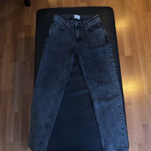Grå loose jeans från Grunt, storlek 25 - Säljer ett par mörkgrå loose fit jeans från Grunt, modellen Street Loose Dark Grey. Jeansen har fem fickor, hög midja och raka ben med en cool tvättad look. Tillverkade i ekologisk bomull för extra skön känsla. Perfekt för dig som gillar avslappnad stil.