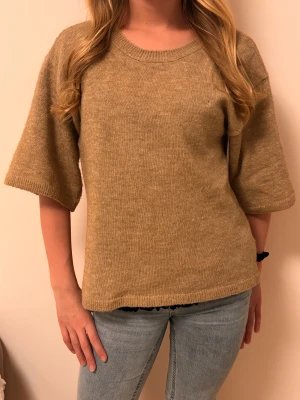 Beige stickad tröja med vida ärmar - Enkel och snygg beige stickad tröja med rund halsringning och vida armar från H&M. 💕 Modellen är ungefär 158 cm och bär storlek 170.☺️ Har ett litet mål på framsidan (bröstet).