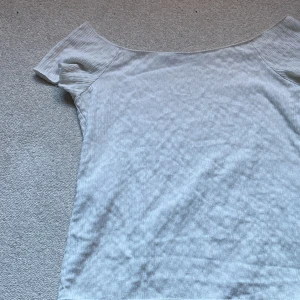 Vit offshoulder topp från 157 - Säljer en vit offshoulder topp från 157 i storlek M. Toppen har korta ärmar och är gjord i ett ribbat, mjukt material som ger en skön känsla. Perfekt för dig som gillar enkel och stilren design med en modern touch.