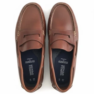 Bruna seglarskor från Marks & Spencer - Snygga bruna seglarskor från Marks & Spencer i skinn med klassisk rund tå och kontrasterande ljusa sömmar. Skorna har dekorativa snörningsdetaljer på sidorna och en platt sula som ger en chill och tidlös look. Perfekta för dig som gillar stilren design.