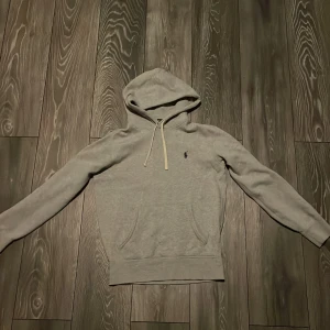 Grå hoodie från Polo Ralph Lauren XS - Snygg grå hoodie från Polo Ralph Lauren, knappt använd i skador eller slitningar. Tröjan är i storlek XS. Nypris cirka 1300kr. Hör av dig vid funderingar! Pris kan diskuteras.