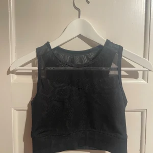 Svart croppad linnetopp från Stronger - Croppad sporttopp/bh från Stronger. Toppen är ärmlös och har en tight passform som sitter snyggt på kroppen. Perfekt för träning eller när du vill ha en sportig vibe. Har tyvärr inga bilder på då den är för liten på mig:(