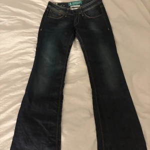 Mörkblå bootcut jeans - Snygga mörkblå jeans med låg midja. Skulle säga att de är i storlek 32-34. Kan skicka mått vid intresse. Säljer pågrund av att dem är för små.
