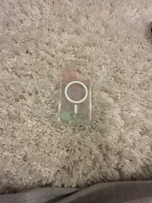 Ideal of Sweden MagSafe Skal - Snyggt och stilrent MagSafe-kompatibelt mobilskal från Ideal of Sweden. Skalets pärlemorskimrande finish ger ett exklusivt intryck och passar iPhone 15 modeller med MagSafe. Skicket är mycket bra, utan synligt slitage eller repor.