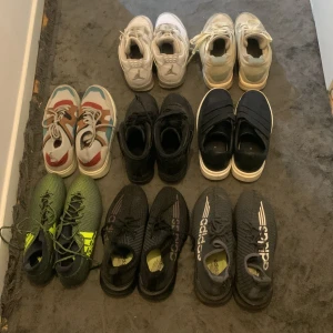 Sneakerpaket med Adidas, Nike och Jordan - Säljer ett paket med sneakers och fotbollsskor: två par svarta Adidas sneakers med vit logga, ett par gröna Adidas fotbollsskor med neon-detaljer, ett par vita Jordan 4 sneakers, ett par svarta Nike high-top sneakers, ett par svarta Zara sneakers med kardborreband och ett par färgglada sneakers med mönster i blått, rött och brunt.