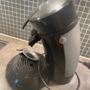 Senseo Original Kaffemaskin - Senseo Original kaffemaskin från Philips, svart färg. Enkel att använda med kaffepads för snabb och god kaffe. Maskinen är i begagnat skick med synligt slitage och damm, men fungerar som den ska. Perfekt för dig som vill ha kaffe snabbt och smidigt hemma.