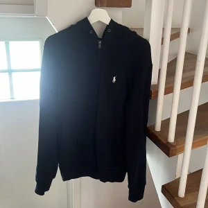 Mörkblå hoodie från Polo Ralph Lauren - Mörkblå hoodie från Polo Ralph Lauren med vit logga på bröstet. Storlek M. Skick 8/10. Meddela vid frågor! 