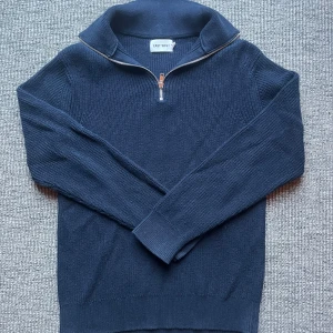 Mörkblå stickad half zip-tröja East West - Mörkblå stickad tröja från East West med half zip-dragkedja och hög krage. Tröjan har lång ärm och är ribbstickad för en snygg struktur. Perfekt för lager-på-lager under kyliga dagar. Nypris 900kr. Skickar inom 1-2 dagar. Svarar snabbt vid frågor och funderingar. Kom Järna med prisförslag. 
