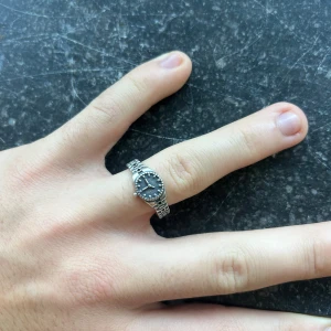 Silverring som ser ut som en klocka - En väldigt cool silverring 925. Den ser ut som en klocka och är öppen under för att den ska passa många storlekar. 