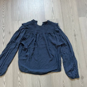 Mörkblå blus med rynkade detaljer - Säljer en mörkblå blus med långa puffärmar. Knappt använd och i mycket bra skick. 