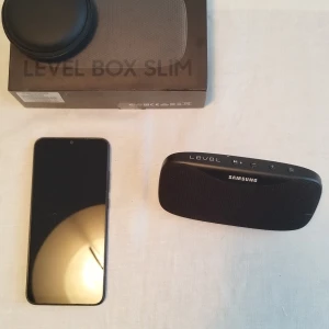 Redmi 9A+Samsung Bluetooth Högtalare+Bluetooth Hörlurar ALLT I NY SKICK!!!! - Redmi 9A+Samsung Bluetooth Högtalare+Bluetooth Hörlurar  ALLT I NY SKICK!!!!                                                                                        Samsung Level Box Slim är en portabel Bluetooth-högtalare med elegant design och tydliga knappar. Produkten ser ut att vara i gott skick och levereras med originalkartong och fodral. Perfekt för musik på språng eller hemma.