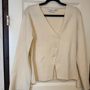 Beige kofta från Kappahl med knappar - Snygg beige kofta från Kappahl i storlek XS. Koftan har v-ringning, tre knappar framtill och är långärmad. 