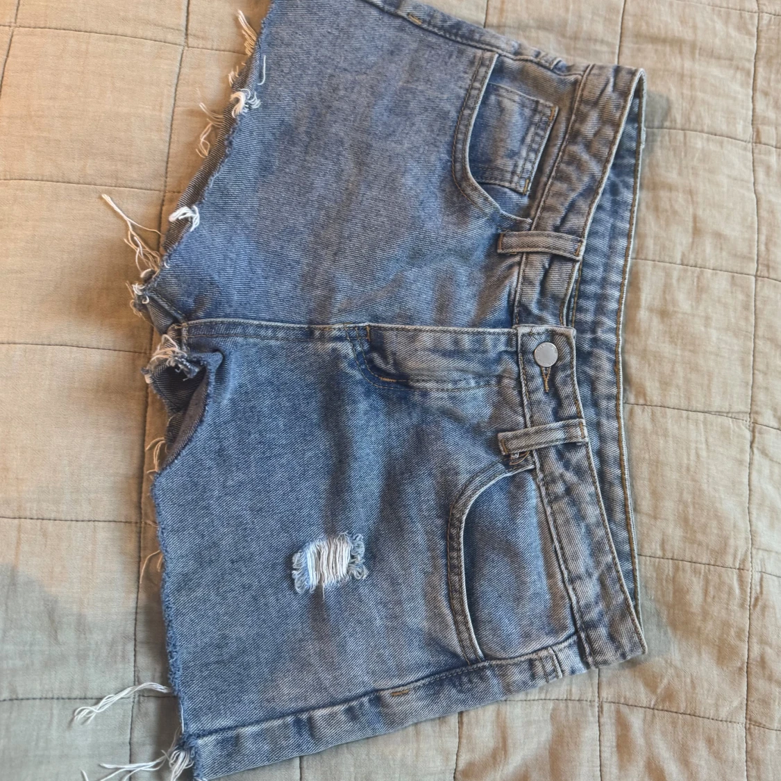 Blå jeansshorts med slitna detaljer