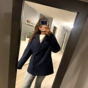 Mörkblå kappa - Säljer min kappa då den inte kommer till användning. Jackan har inga defekter eller täcken på användning. Den är max använda tre gånger. Om vi har några frågor eller vill ha fler bilder är de bara att skriva. Är villig att gå ner i pris vid snabb affär!