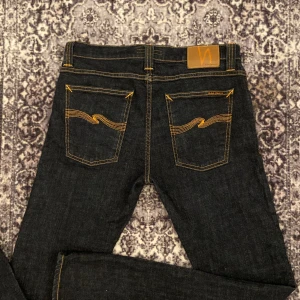 🚨Skitnygga mörkblå jeans från Nudie Jeans🚨 - 🚨Skitsnygga jeans Nudie!🚨Storlek 31/32.Får en skitsnygg fade efter användning. De är i ett mycket bra skick och det är inga defekter✅Var inte rädd för att buda eller fråga frågor⚠️