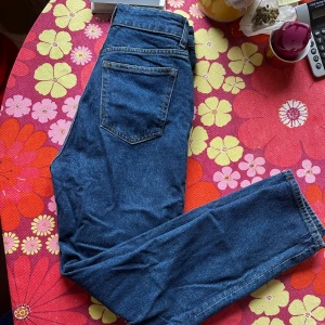 Mörkblå high waist jeans från H&M - Snygga mörkblå tapered högmidjade ankel jeans från H&M. 