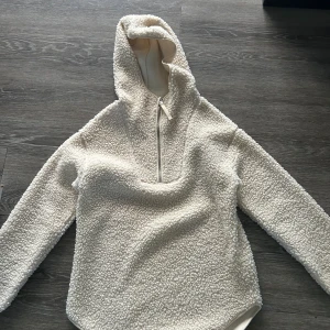 Beige teddy hoodie från H&M - Beige teddy hoodie från H&M med huva och halv dragkedja. Oversized och tunnare fleecejacka