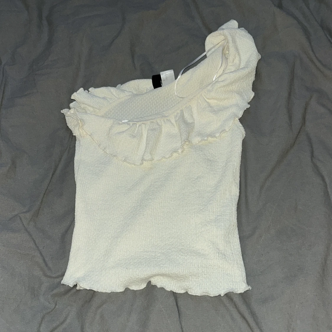 Krämvit oneshoulder topp från H&M