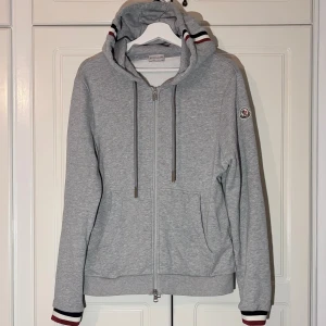 Grå Moncler zip hoodie - Grå hoodie Moncler zip hoodie i nyskick. Storlek M, säljer den för att den var lite för liten för mig. Skönt material och clean. 