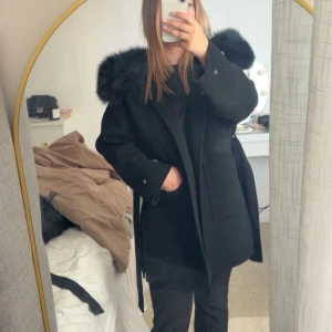 Populär svart kappa  - En super varm kappa som håller ute höst/vinter kylan jätte bra! Strlk Xs Passform Xs/S.         Väl omhändertagen, inget knotter och pälsen är len och fluffig.        Inga defekter.               Pris kan diskuteras💗💗