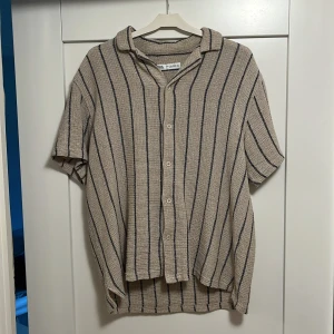 Beige randig skjorta från Zara - Kortärmad skjorta från Zara i storlek Large.
