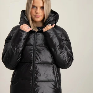 Svart pufferjacka  - Säljer en svart pufferjacka med glansig finish och stor huva. Jackan har dragkedja framtill, två fickor på sidorna och breda kanaler för en riktigt puffig look. Perfekt för kalla dagar och riktigt snygg till jeans. Typ aldrig använt 